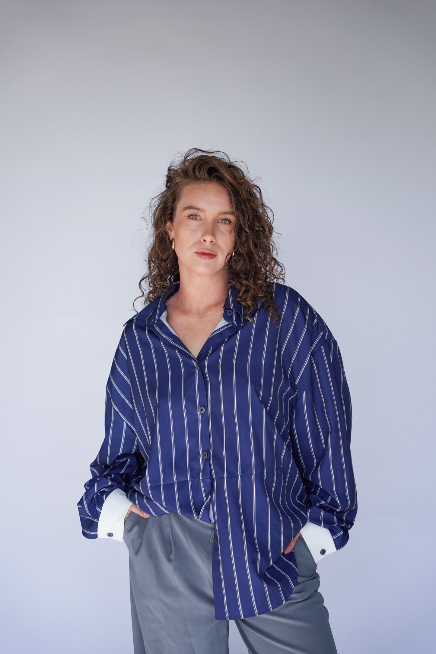 Woman wearing a blue striped shirt against a plain background