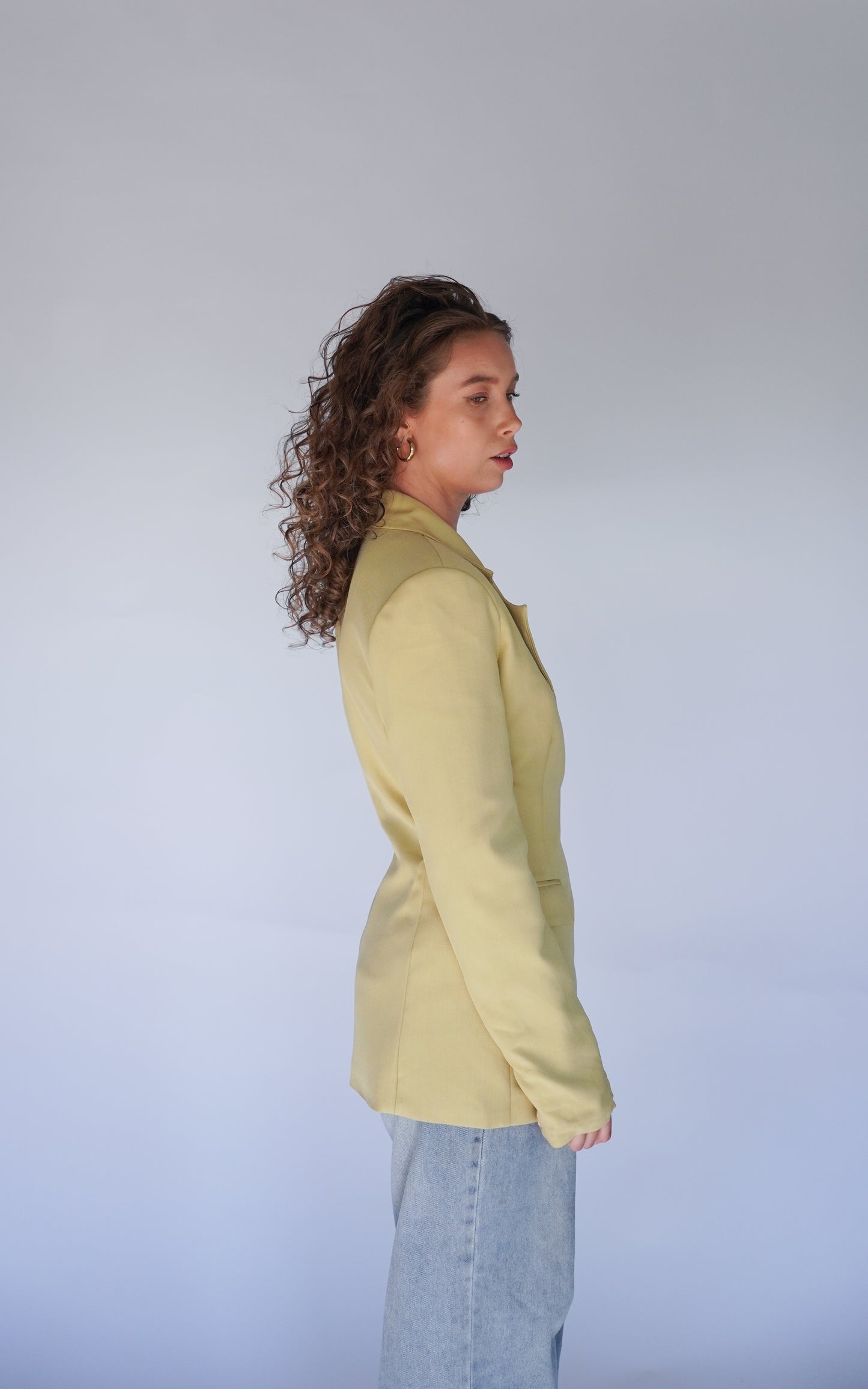 Person wearing a light green blazer against a plain background