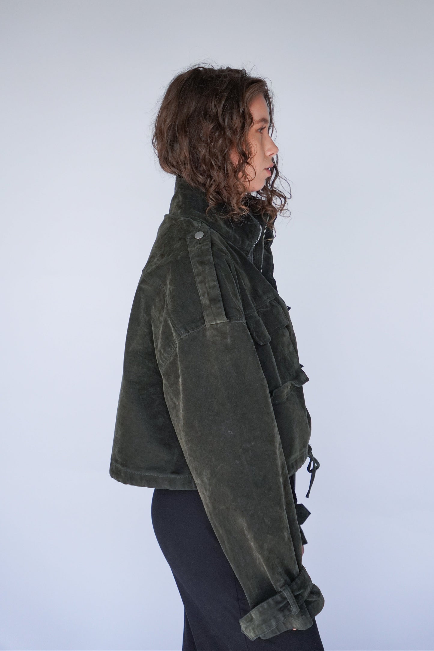 Person wearing a green jacket on a plain background