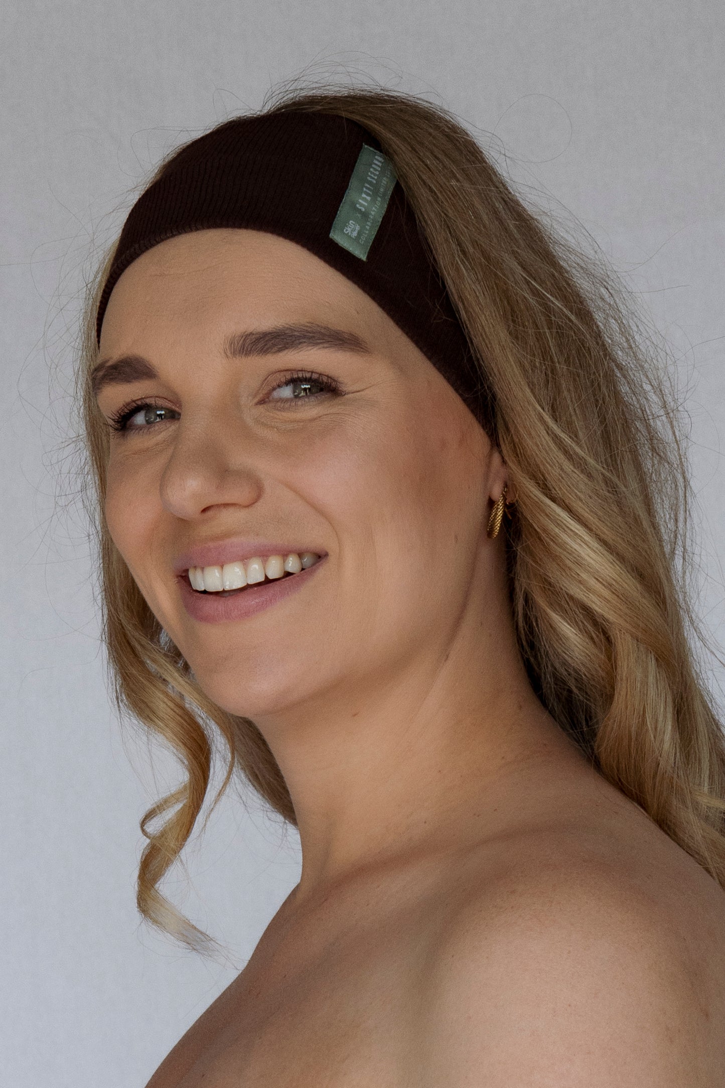 Woman wearing a brown headband with a white background