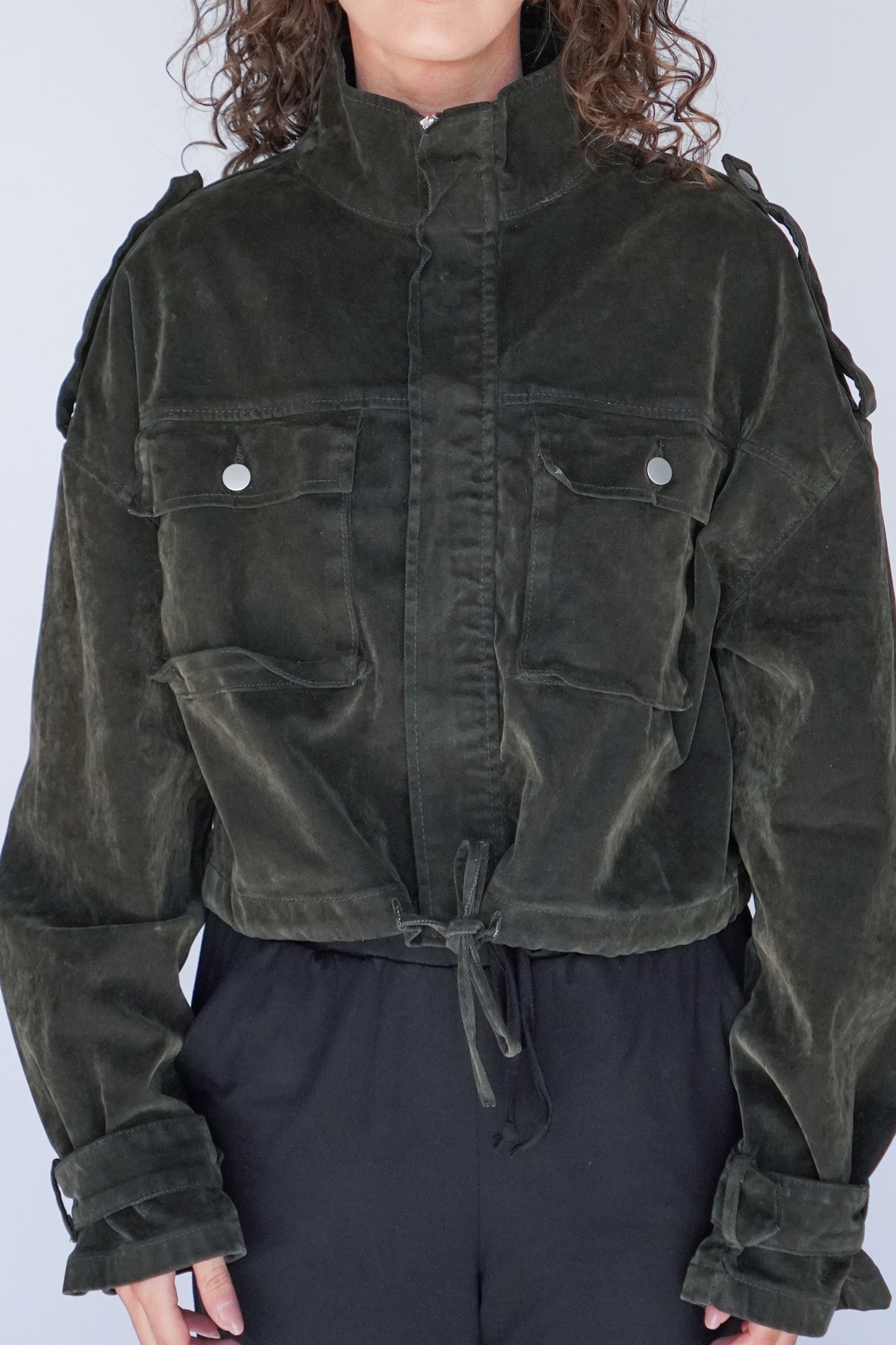 Dark green jacket worn by a person against a plain background